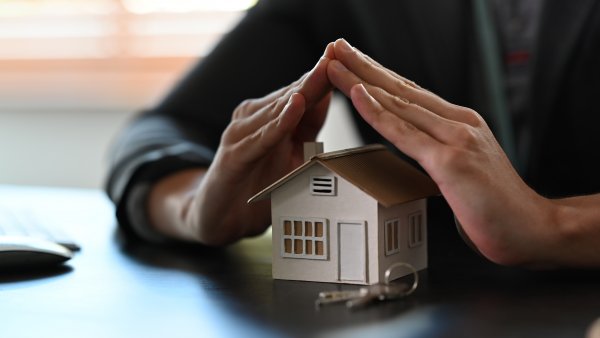 cropped-image-of-small-house-covered-by-hands-pro-2022-02-09-01-02-59-utc.JPG